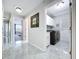 Hallway leading to bedroom, featuring marble floors, a laundry room with black washer/dryer, and decorative mirror at 5249 Wellfield Rd, New Port Richey, FL 34655