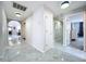 Hallway with white marble floors and access to various rooms creating an airy and connected living space at 5249 Wellfield Rd, New Port Richey, FL 34655