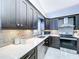 Modern kitchen featuring stainless steel appliances, dark wood cabinets, a stylish backsplash, and plenty of counter space at 5249 Wellfield Rd, New Port Richey, FL 34655