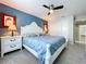 Main bedroom boasts a blue accent wall, ceiling fan, and closet, with adjacent access to other areas of the house at 5249 Wellfield Rd, New Port Richey, FL 34655