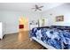 Bright main bedroom with wood-look floors, ceiling fan, and access to the en suite bathroom and walk-in closet at 5249 Wellfield Rd, New Port Richey, FL 34655