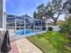 This home features a pristine swimming pool and patio inside of a screened enclosure at 5249 Wellfield Rd, New Port Richey, FL 34655