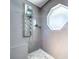 Modern shower with gray tiling, a rain shower head, and a mosaic tile floor at 5249 Wellfield Rd, New Port Richey, FL 34655