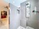 The luxury shower features modern fixtures, sleek gray tiles, a built-in niche, and is attached to the walk-in closet at 5249 Wellfield Rd, New Port Richey, FL 34655