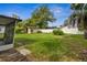 View of the backyard with a shed, partial screened in porch and wood fence in a residential neighborhood at 5323 23Rd St, Zephyrhills, FL 33542