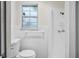 Bright white tiled bathroom with a window and shower at 5323 23Rd St, Zephyrhills, FL 33542