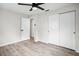 Bright bedroom features a ceiling fan, closet, and wood-look flooring at 5323 23Rd St, Zephyrhills, FL 33542