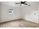 Cozy bedroom features wood-look flooring, a ceiling fan, and a bright window at 5323 23Rd St, Zephyrhills, FL 33542