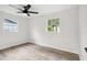 Bright bedroom features two windows, light wood floors, and neutral paint at 5323 23Rd St, Zephyrhills, FL 33542