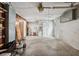 Unfinished garage space with water heater, shelving, and door at 5323 23Rd St, Zephyrhills, FL 33542