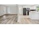 Open-concept kitchen and living area with wood floors, white cabinets, and modern appliances at 5323 23Rd St, Zephyrhills, FL 33542