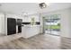 A modern kitchen with white cabinets, black appliances, a breakfast bar, and access to the patio at 5323 23Rd St, Zephyrhills, FL 33542