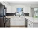 Updated kitchen with white cabinets, black appliances, and black tile backsplash at 5323 23Rd St, Zephyrhills, FL 33542