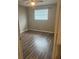 View into a bedroom featuring wood-look flooring, a window and tan walls at 5708 Townhouse Dr # 5708, New Port Richey, FL 34652