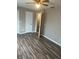 A tan bedroom features wood-look flooring and a ceiling fan with an open closet door at 5708 Townhouse Dr # 5708, New Port Richey, FL 34652