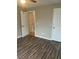 A tan bedroom features wood-look flooring and doors to both the closet and bathroom at 5708 Townhouse Dr # 5708, New Port Richey, FL 34652