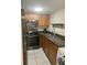 Updated kitchen featuring wood cabinets, black appliances, and ample counter space at 5708 Townhouse Dr # 5708, New Port Richey, FL 34652