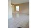 Open-concept living room boasts tiled floors, neutral walls, and ample natural light from a large window at 5708 Townhouse Dr # 5708, New Port Richey, FL 34652