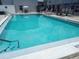 Beautiful clear blue swimming pool with poolside seating and palm trees at 5708 Townhouse Dr # 5708, New Port Richey, FL 34652