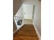A view down the stairs featuring wood treads, white risers and a white railing with tile landing at 5708 Townhouse Dr # 5708, New Port Richey, FL 34652