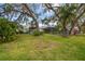A large, grassy backyard with a screened-in pool area and ample space for outdoor activities and entertaining at 6046 River Rd, New Port Richey, FL 34652