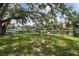 Lush backyard with mature trees and a black fence, offering serene waterfront views and privacy at 6046 River Rd, New Port Richey, FL 34652