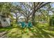 Expansive backyard featuring a cozy seating area under a mature tree, perfect for outdoor gatherings at 6046 River Rd, New Port Richey, FL 34652