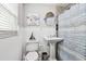 Bright bathroom with white wainscoting, pedestal sink, and tasteful decor creating a clean, inviting space at 6046 River Rd, New Port Richey, FL 34652