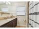 Well-lit bathroom with a granite countertop, dark wood vanity, and decorative accents offering a stylish, functional space at 6046 River Rd, New Port Richey, FL 34652