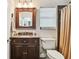 Cozy bathroom features a wood vanity, a large mirror, a marble countertop, and a shower with decorative tile at 6046 River Rd, New Port Richey, FL 34652