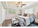 Cozy bedroom with a ceiling fan, tray ceiling, hardwood floors, and natural light at 6046 River Rd, New Port Richey, FL 34652