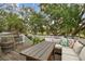 Spacious deck featuring outdoor furniture, a barrel table, and lush trees providing shade and a serene atmosphere at 6046 River Rd, New Port Richey, FL 34652