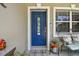 Close-up of a beautiful blue front door with decorative glass, surrounded by stylish decor and a welcoming atmosphere at 6046 River Rd, New Port Richey, FL 34652