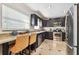 Modern kitchen featuring stainless steel appliances, dark cabinets, granite countertops, and a breakfast bar with seating at 6046 River Rd, New Port Richey, FL 34652