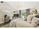 Charming bedroom features a decorative chandelier, neutral walls, hardwood floors, and sliding glass doors to the back patio at 6046 River Rd, New Port Richey, FL 34652