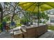 Inviting outdoor patio with lounge furniture, shade from a large umbrella, and lush landscaping for relaxation at 6046 River Rd, New Port Richey, FL 34652