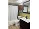 Bathroom with tub/shower combo, unique wood cabinet and updated sink at 6108 Maplewood Dr, New Port Richey, FL 34653