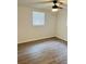 Bright bedroom featuring wood-look flooring, ceiling fan, and window with blinds at 6108 Maplewood Dr, New Port Richey, FL 34653