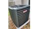 Goodman HVAC unit on concrete pad on the side of house with greenery and leaves nearby at 6108 Maplewood Dr, New Port Richey, FL 34653