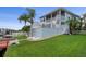 Spacious backyard featuring a well-manicured lawn and staircase to the home, near the waterfront at 6140 Seaside Dr, New Port Richey, FL 34652