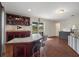 Open bar area with tile countertops, custom cabinets, and views of the outdoor pool and patio at 6140 Seaside Dr, New Port Richey, FL 34652