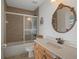Well-maintained bathroom featuring a shower-tub combination and a decorative oval mirror at 6140 Seaside Dr, New Port Richey, FL 34652