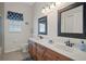 Bathroom featuring a double sink vanity with wood cabinets, neutral walls and floors, and updated fixtures at 6140 Seaside Dr, New Port Richey, FL 34652