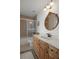 Bright bathroom featuring a vanity with wood cabinets and a shower-tub combination with tile surround at 6140 Seaside Dr, New Port Richey, FL 34652