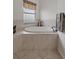 Bathroom featuring a bright soaking tub with beige tile surround at 6140 Seaside Dr, New Port Richey, FL 34652
