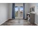 Bright bedroom featuring wood-look floors, light gray walls, and French doors that offer plenty of natural light at 6140 Seaside Dr, New Port Richey, FL 34652