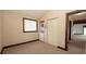 Laundry room with a stacked washer and dryer, a window, carpet flooring and wood trim at 6322 Aureau Ave, Hudson, FL 34667