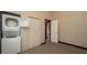 Laundry room with a stacked washer and dryer, a window, carpet flooring and closet at 6322 Aureau Ave, Hudson, FL 34667