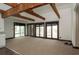 Bright living room featuring exposed beams and multiple windows and balcony access at 6322 Aureau Ave, Hudson, FL 34667