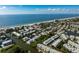 Expansive aerial view showcases waterfront homes with docks and beach access along the coastline under a clear blue sky at 639 Garland Cir, Indian Rocks Beach, FL 33785